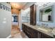 Bathroom area with dual sinks, granite counters and wood cabinets with a laundry chute at 2691 Saddlewood Ln, Palm Harbor, FL 34685