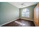 Bedroom with hardwood floors, ceiling fan, and large arched window at 2691 Saddlewood Ln, Palm Harbor, FL 34685
