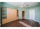Spacious bedroom with hardwood floors, a ceiling fan, and a custom storage unit at 2691 Saddlewood Ln, Palm Harbor, FL 34685