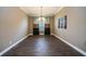 Formal dining room with dark wood floors, chandelier, and large window at 2691 Saddlewood Ln, Palm Harbor, FL 34685