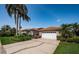 Beautiful single-story home featuring a large driveway, lush landscaping and a clay tile roof at 2691 Saddlewood Ln, Palm Harbor, FL 34685