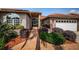Close up of home's entry with brick walkway, an arched doorway, and lush landscaping at 2691 Saddlewood Ln, Palm Harbor, FL 34685