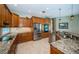 Bright kitchen featuring stone countertops, custom cabinetry and stainless steel appliances at 2691 Saddlewood Ln, Palm Harbor, FL 34685