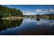 Scenic view of a calm lake reflecting the sky and the tree lined shore at 2691 Saddlewood Ln, Palm Harbor, FL 34685