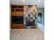 Cozy living room with a beautiful stone fireplace, built-in shelves, and tile flooring at 2691 Saddlewood Ln, Palm Harbor, FL 34685