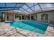 In-ground pool and spa under screened lanai with tile deck at 2691 Saddlewood Ln, Palm Harbor, FL 34685