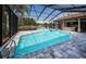 In-ground pool with spa and lake view from covered, screened-in lanai at 2691 Saddlewood Ln, Palm Harbor, FL 34685