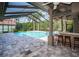Enclosed pool area with bar, ceiling fans, and view of the water at 2691 Saddlewood Ln, Palm Harbor, FL 34685