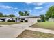 Ranch-style home featuring a well-manicured lawn, mature trees, and paved driveway at 2914 Forest Cir, Seffner, FL 33584