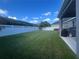 Spacious backyard with lush lawn, white fence, and covered patio at 33191 Azalea Ridge Dr, Wesley Chapel, FL 33545