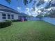 Spacious backyard with lush lawn, white fence, and covered patio at 33191 Azalea Ridge Dr, Wesley Chapel, FL 33545