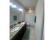 Bathroom with dual sinks, granite countertop, white shower curtain, and ample lighting for a refreshing experience at 33191 Azalea Ridge Dr, Wesley Chapel, FL 33545