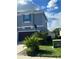 Features a two car garage and a well manicured yard with green bushes and green grass at 33191 Azalea Ridge Dr, Wesley Chapel, FL 33545