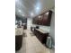 Well-equipped kitchen featuring dark wood cabinetry, granite countertops, and stainless steel appliances at 33191 Azalea Ridge Dr, Wesley Chapel, FL 33545