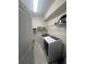 Functional laundry room with modern appliances and built-in shelving for storage, perfect for efficient chores at 33191 Azalea Ridge Dr, Wesley Chapel, FL 33545