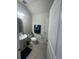 Well-lit powder room with pedestal sink, modern fixtures, and a clean, minimalist design at 33191 Azalea Ridge Dr, Wesley Chapel, FL 33545