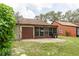 Backyard featuring screened-in patio, grill, concrete patio, and exterior of home at 35077 Whispering Oaks Blvd, Dade City, FL 33523