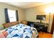 Bright bedroom with a window, quilt bedding, television, and furnishings at 35077 Whispering Oaks Blvd, Dade City, FL 33523