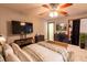 Comfortable bedroom with a ceiling fan, TV, and a view into the walk-in closet at 35077 Whispering Oaks Blvd, Dade City, FL 33523