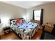 Cozy bedroom with a blue and white quilt, side table, and natural light from the window at 35077 Whispering Oaks Blvd, Dade City, FL 33523
