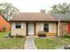 Cozy one-story home featuring neutral siding, white shutters, and a welcoming front entrance at 35077 Whispering Oaks Blvd, Dade City, FL 33523