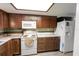 Practical kitchen features brown cabinets, white appliances, and tile floors at 35077 Whispering Oaks Blvd, Dade City, FL 33523