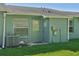 Back door and small outdoor area of the home with lawn and an air conditioning unit at 38237 Eucalyptus Dr, Zephyrhills, FL 33542