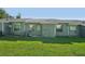 The home's backyard has green grass, windows, and back door access to the home at 38237 Eucalyptus Dr, Zephyrhills, FL 33542