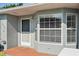 Inviting front entrance featuring a storm door and multiple windows for lots of natural light at 38237 Eucalyptus Dr, Zephyrhills, FL 33542