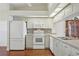 Bright kitchen featuring white appliances, cabinets and a mosaic tile backsplash at 38237 Eucalyptus Dr, Zephyrhills, FL 33542