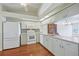 Light and airy kitchen with white cabinets, appliances, and hardwood floors at 38237 Eucalyptus Dr, Zephyrhills, FL 33542