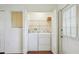 Convenient laundry room with washer, dryer, and shelving for storage, as well as access to the outside at 38237 Eucalyptus Dr, Zephyrhills, FL 33542