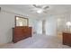Bright main bedroom featuring a ceiling fan, and large dressers with access to the bathroom at 38237 Eucalyptus Dr, Zephyrhills, FL 33542