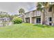 Exterior of a two-story condo building with balconies overlooking a well-manicured lawn and beautiful landscaping at 4215 E Bay Dr # 1706A, Clearwater, FL 33764