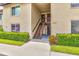 Exterior of a well-maintained condo building featuring tidy landscaping and a staircase leading to the upper units at 4215 E Bay Dr # 1706A, Clearwater, FL 33764