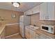 Compact kitchen featuring white appliances, cabinets, and a double basin sink with beige countertop at 4215 E Bay Dr # 1706A, Clearwater, FL 33764