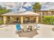 Outdoor seating area with a large table, chairs, and shade under an umbrella near the community pool at 4215 E Bay Dr # 1706A, Clearwater, FL 33764