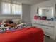 Comfortable bedroom features a large bed, dresser with mirror, and ample natural light from the window at 4219 Gray Squirrel Ln, New Port Richey, FL 34653