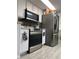 Modern kitchen featuring stainless steel appliances, granite countertops, tile backsplash, and ample storage at 4219 Gray Squirrel Ln, New Port Richey, FL 34653