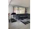Cozy living room featuring a large sectional sofa, modern rug, and exercise equipment at 4219 Gray Squirrel Ln, New Port Richey, FL 34653