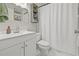 Bright, modern bathroom with a sleek white vanity, decorative mirror, and tiled shower at 4613 Summerwind Ct, Plant City, FL 33566