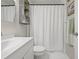 Clean bathroom featuring white vanity, decorative mirror, and tiled shower with curtain at 4613 Summerwind Ct, Plant City, FL 33566
