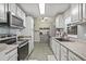 Well-lit kitchen featuring white cabinets and stainless steel appliances at 4613 Summerwind Ct, Plant City, FL 33566