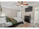 Cozy main bedroom featuring a ceiling fan, mounted TV, and convenient access to a closet and ensuite bathroom at 4613 Summerwind Ct, Plant City, FL 33566