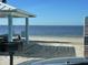 Relaxing beachfront with a picnic shelter, grill, and stunning water view on a sunny day at 4712 Marine Pkwy # 203, New Port Richey, FL 34652