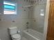 Tiled bathroom featuring a bathtub and shower with a wooden cabinet at 5106 Gateway Dr, Tampa, FL 33615