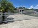 Gated home featuring landscaping, driveway, and palm trees at 5106 Gateway Dr, Tampa, FL 33615