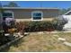 Landscaped yard featuring vibrant flowers, lush greenery, a charming statue and a natural stone pathway at 5106 Gateway Dr, Tampa, FL 33615