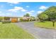Charming single-story home with a paved driveway, a well-manicured lawn, and mature trees at 5821 52Nd N Ave, Kenneth City, FL 33709
