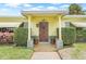 Charming home's front entrance showcases a stylish door with potted plants and well-maintained landscaping at 5821 52Nd N Ave, Kenneth City, FL 33709